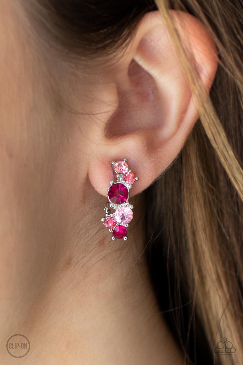 Cosmic Celebration Pink Clip-On Earring - Paparazzi Accessories  Varying in shades of pink, mismatched rhinestones delicately coalesce into a dainty frame for a colorfully sparkly display. Earring attaches to a standard clip-on fitting.  Sold as one pair of clip-on earrings.