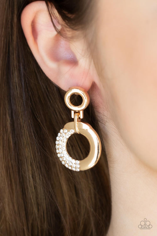 Modern Motivation Gold Earring - Paparazzi Accessories  A dainty gold hoop attaches to a shimmery gold ring that is half dipped in glassy white rhinestones, creating a modern look. Earring attaches to a standard post fitting.  Sold as one pair of post earrings.