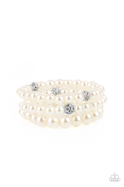 Here Comes The Heiress White Pearl Bracelet - Paparazzi Accessories  Infused with white rhinestone encrusted silver beads, a bubbly collection of mismatched white pearls are threaded along stretchy bands around the wrist for a vintage inspired layered look.  All Paparazzi Accessories are lead free and nickel free!  Sold as one set of three bracelets.
