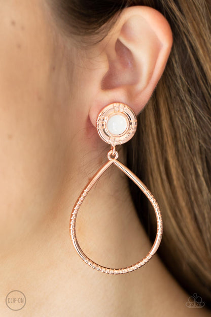 Fairytale Finish Copper Clip-On Earring - Paparazzi Accessories  A milky white bead is pressed into the center of a textured shiny copper fitting that attaches to an oversized textured shiny copper teardrop, creating an ethereal lure. Earring attaches to a standard clip-on earring.  Sold as one pair of clip-on earrings.
