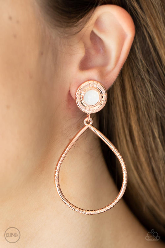 Fairytale Finish Copper Clip-On Earring - Paparazzi Accessories  A milky white bead is pressed into the center of a textured shiny copper fitting that attaches to an oversized textured shiny copper teardrop, creating an ethereal lure. Earring attaches to a standard clip-on earring.  Sold as one pair of clip-on earrings.