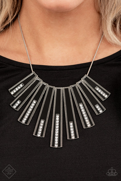 FAN-tastically Deco Black Necklace - Paparazzi Accessories  Elongated flared frames are painted in a glossy black finish and bordered by studded texture as they fan out along the collar. A row of rhinestones runs up the center of each frame, adding spectacular sparkle to the display as the pieces sway from a round silver chain. Features an adjustable clasp closure.  All Paparazzi Accessories are lead free and nickel free!  Sold as one individual necklace. Includes one pair of matching earrings.