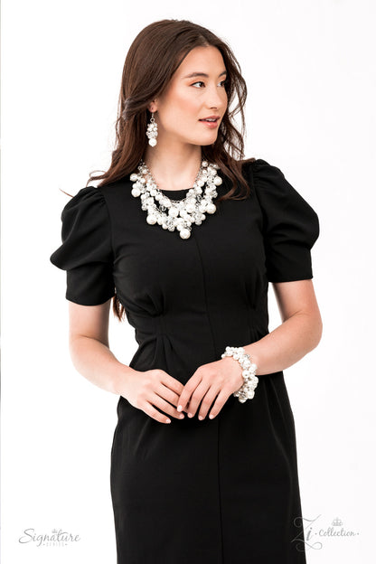 An elegantly effervescent collection of oversized pearls, glassy crystal-like beads, and white rhinestone studded silver ornaments effortlessly clusters along two bold silver chains below the collar. The bubbly bunched accents glamorously gather into a brilliantly boisterous fringe for an uproarious uptown fashion. Features an adjustable clasp closure.  All Paparazzi Accessories are lead free and nickel free!