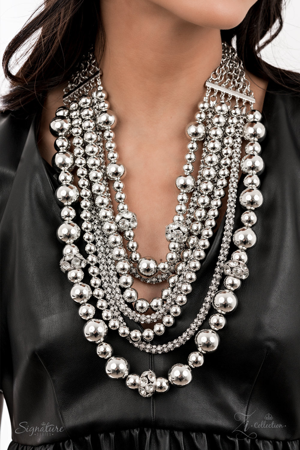 Held together by rectangular silver frames, a couture-clutching collection of oversized silver beads interspersed with white rhinestone encrusted ornaments alternates with interlocking rows of white rhinestone encrusted chains across the chest. Edgily enhanced with linked rows of silver chain fittings, the emboldened silver layers demand to be seen with their unapologetic attitude. Features an adjustable clasp closure.  All Paparazzi Accessories are lead free and nickel free!