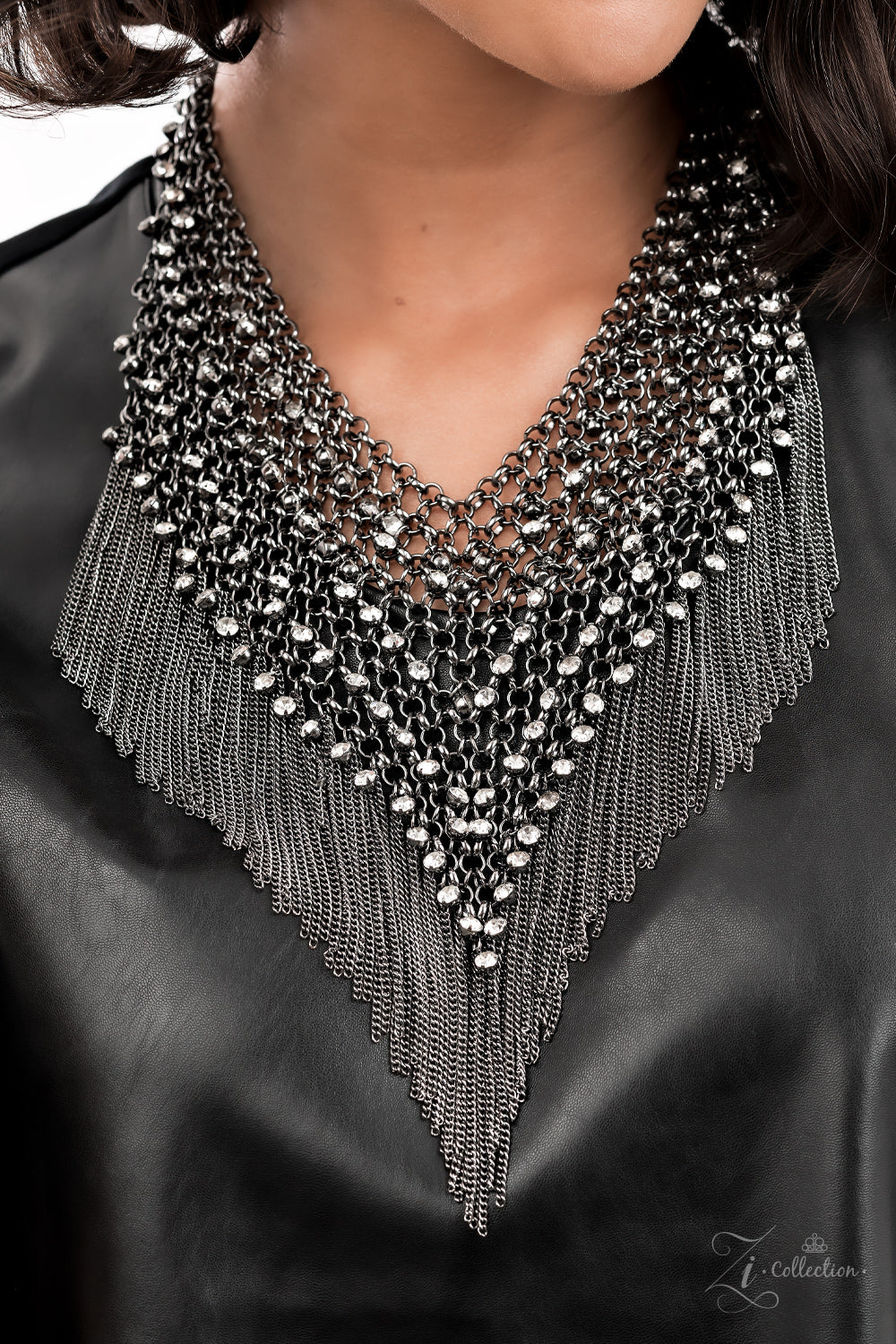 Impulsive 2021 Zi Collection Necklace - Paparazzi Accessories  Row after row of blinding white rhinestones trickle from a seemingly infinite collection of bold gunmetal links that interlock into an intensely tapered metallic net down the chest. Gritty gunmetal chains stream from the bottom of the glamorously grunge statement piece, adding hypnotic movement to the fearless attitude of this main attraction. Features an adjustable clasp closure. Includes one pair of matching earrings.