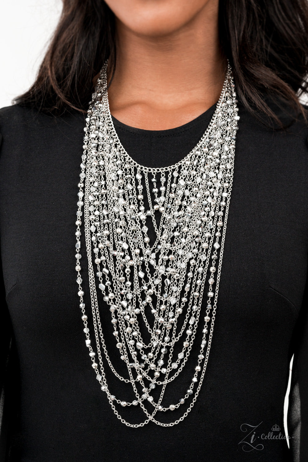Enticing 2021 Zi Collection Necklace - Paparazzi Accessories  An entrancing collection of raw cut, faceted, and crystal-like silver and hematite beads delicately connect into glitzy strands that dauntlessly drape across the chest. Intermixed with plain silver chains, the swooping layers sway with every movement, creating an audaciously audible shimmer. Features an adjustable clasp closure. Sold as one individual necklace. Includes one pair of matching earrings.