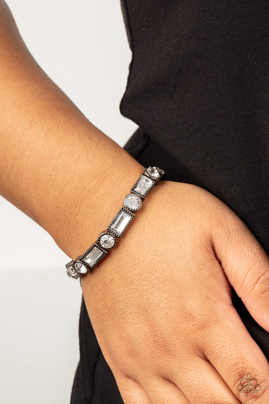 Classic Couture Black Bracelet - Paparazzi Accessories  Classic round and baguette-cut rhinestones set in shiny dotted gunmetal frames alternate around the wrist on stretchy bands for a shimmering finish.  Sold as one bracelet.