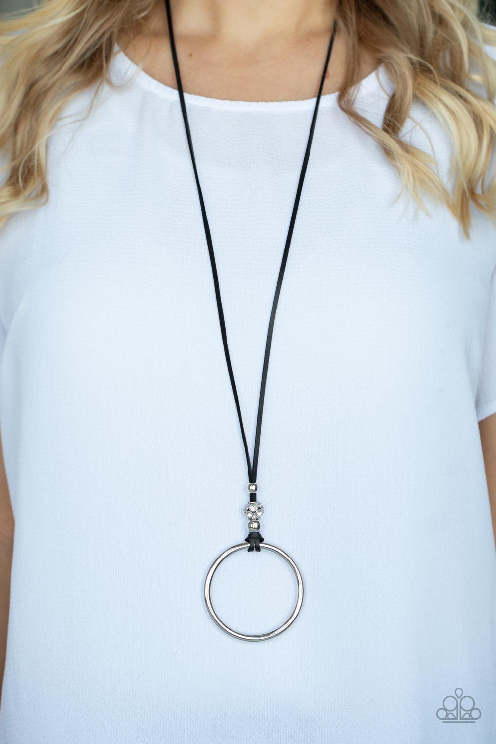 BLING Into Focus Black Necklace - Paparazzi Accessories  Infused with a pair of classic silver beads and a white rhinestone encrusted accent, lengthened black leather cording knots around a bold silver hoop for a knockout look. Features an adjustable clasp closure.  Sold as one individual necklace. Includes one pair of matching earrings.