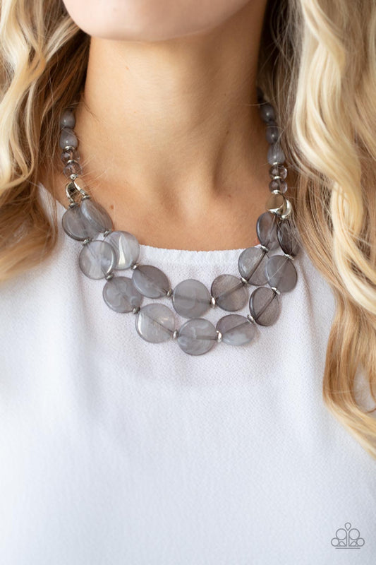 Beach Day Demure Silver Necklace - Paparazzi Accessories  Intermixed with smoky crystal-like beads and shiny silver accents, mismatched cloudy, glassy, and opaque gray teardrop and disc beads layer below the collar for a classic pop of neutral color. Features an adjustable clasp closure.  Sold as one individual necklace. Includes one pair of matching earrings.