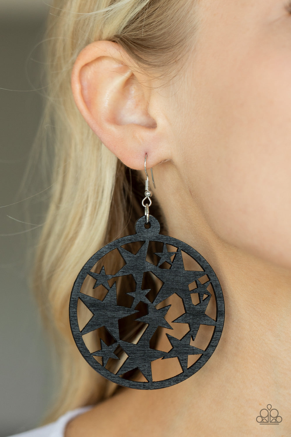 Cosmic Paradise Black Earring - Paparazzi Accessories  An oversized round black wooden frame is filled with a cosmos of cut-out black stars creating a whimsical statement. Earring attaches to a standard fishhook fitting.  Sold as one pair of earrings.