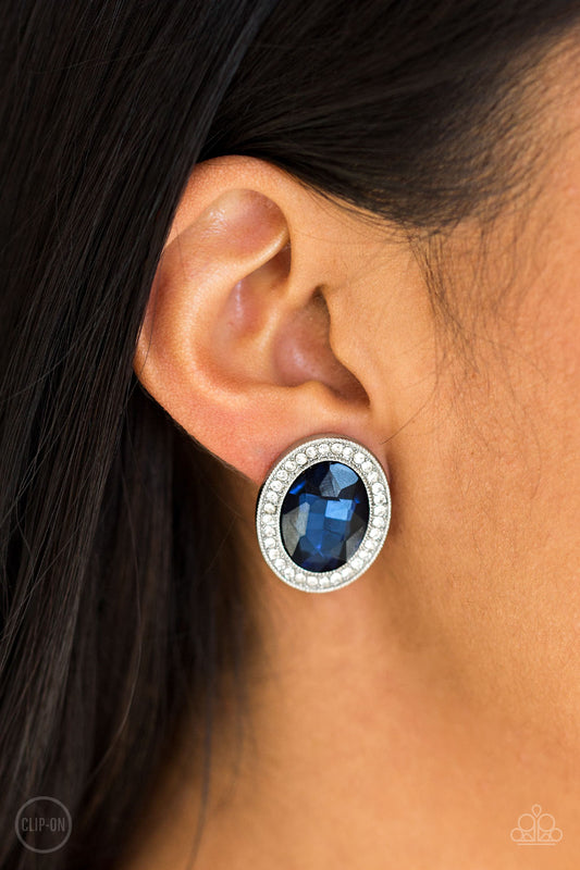 Only FAME In Town - Blue Item #E460 An oversized blue gem is pressed into the center of a silver frame radiating with glassy white rhinestones for a glamorous look. Earring attaches to a standard clip-on fitting. All Paparazzi Accessories are lead free and nickel free!  Sold as one pair of clip-on earrings.
