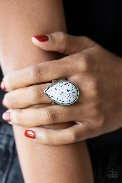 Stormy Sunrise White Ring - Paparazzi Accessories  A generous polished white stone infused with black flecks is encased in a simple silver teardrop frame resulting in a seasonal finish atop the finger. Features a stretchy band for a flexible fit.  Sold as one individual ring.
