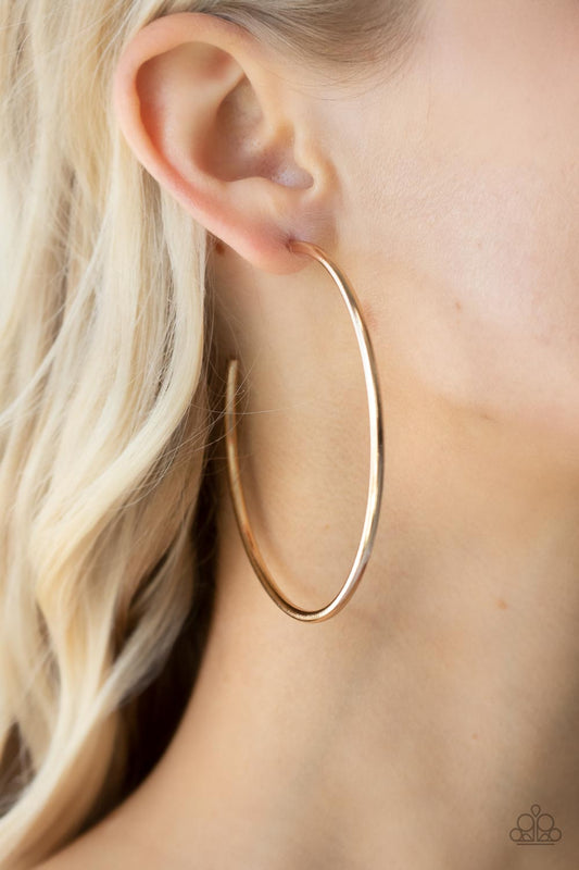 Mega Metro Gold Hoop Earring - Paparazzi Accessories  Featuring a high sheen, a polished gold hoop stands out in a mega way creating a trendy display as it wraps around the ear. Earring attaches to a standard post fitting. Hoop measures approximately 3" in diameter.  Sold as one pair of hoop earrings.