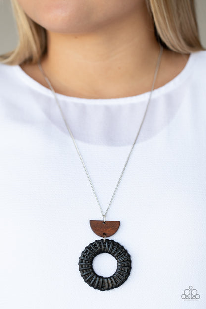 Homespun Stylist Black Necklace - Paparazzi Accessories  Black wicker-like cording wraps into a rustic hoop at the bottom of a half moon wooden frame. The earthy stacked pendants swing from a lengthened silver chain, creating an artisan inspired display. Features an adjustable clasp closure.  Sold as one individual necklace. Includes one pair of matching earrings.