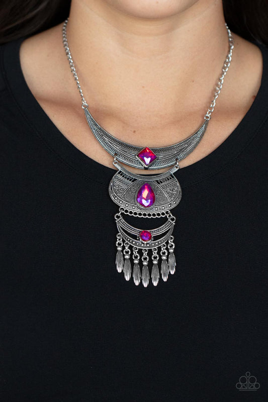 Lunar Enchantment Pink Necklace Embossed in studded, geometric, and paisley filigree-like patterns, three mismatched silver half moon plates dramatically link below the collar. Featuring an entrancing pink UV shimmer, an oversized collection of square, teardrop, and round rhinestones embellish the decorative silver frames, while a silver beaded fringe swings from the lowermost plate for a noisemaking finish. Features an adjustable clasp closure.  Includes one pair of matching earrings.