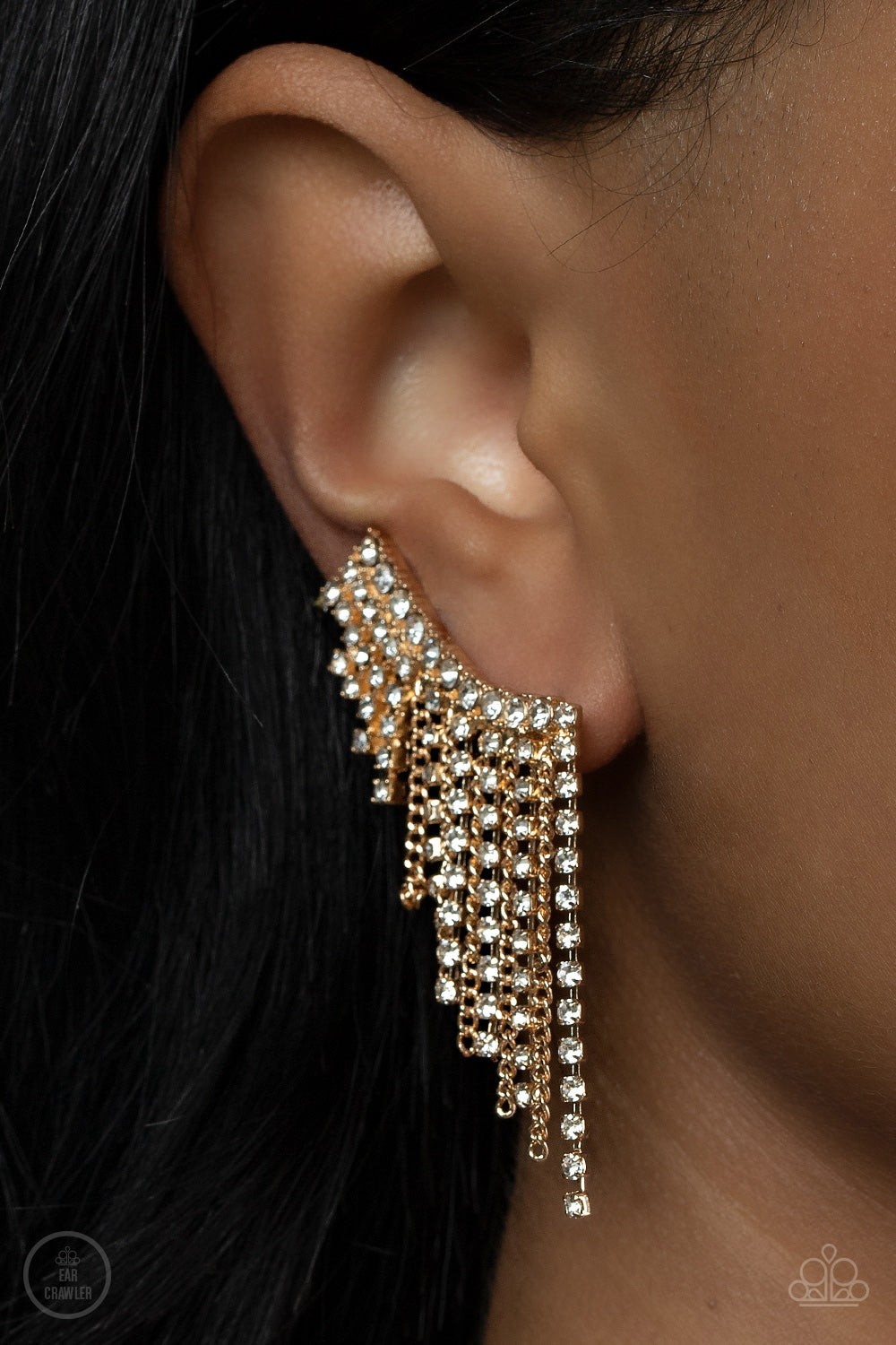 Thunderstruck Sparkle Gold Ear Crawler Earring - Paparazzi Accessories   A tapered fringe of dainty gold chains and glittery strands of white rhinestones cascades from the edge of a curving white rhinestone encrusted frame, creating an edgy centerpiece. Features a clip-on fitting at the top for a secure fit.  Sold as one pair of ear crawlers.