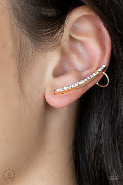 Sleekly Shimmering Gold Ear Crawler Earring - Paparazzi Accessories  Featuring pronged gold fittings, a dainty row of stacked white rhinestones gently curves as it climbs the ear for a flawless fashion. Features a dainty cuff attached to the top for a secure fit.  Sold as one pair of ear crawlers.