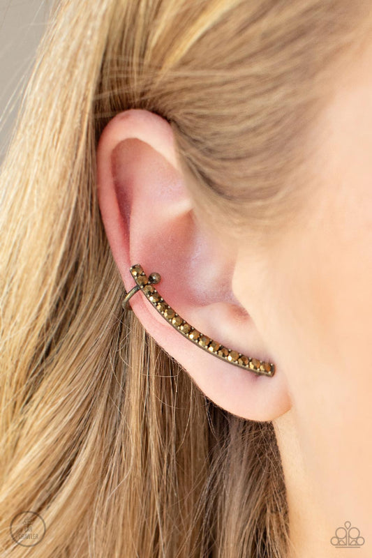 Give Me The SWOOP Brass Post Earring - Paparazzi Accessories  A dainty row of glitzy aurum rhinestones is encrusted along a gritty brass bar that swoops up the ear for a smoldering style. Features a dainty cuff attached to the top for a secure fit.  All Paparazzi Accessories are lead free and nickel free!  Sold as one pair of ear crawlers.