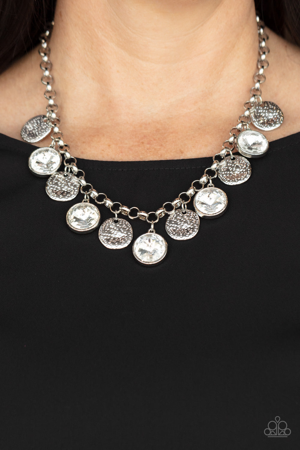 Spot On Sparkle White Necklace - Paparazzi Accessories  A blinding collection of hammered silver discs and oversized white gems swing from the bottom of a bold silver chain, creating noise-making sparkle below the collar. Features an adjustable clasp closure.  All Paparazzi Accessories are lead free and nickel free!  Sold as one individual necklace. Includes one pair of matching earrings.
