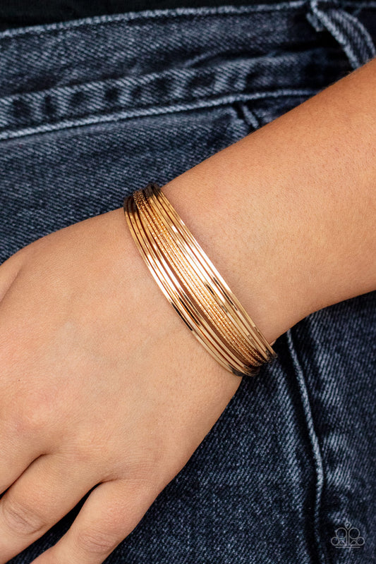This Girl is on WIRE - Gold Item #P9BA-GDXX-094XX Capped in gold fittings, rows of smooth gold wires flank a section of diamond cut gold wire around the wrist, creating an edgy cuff.  Sold as one individual bracelet.
