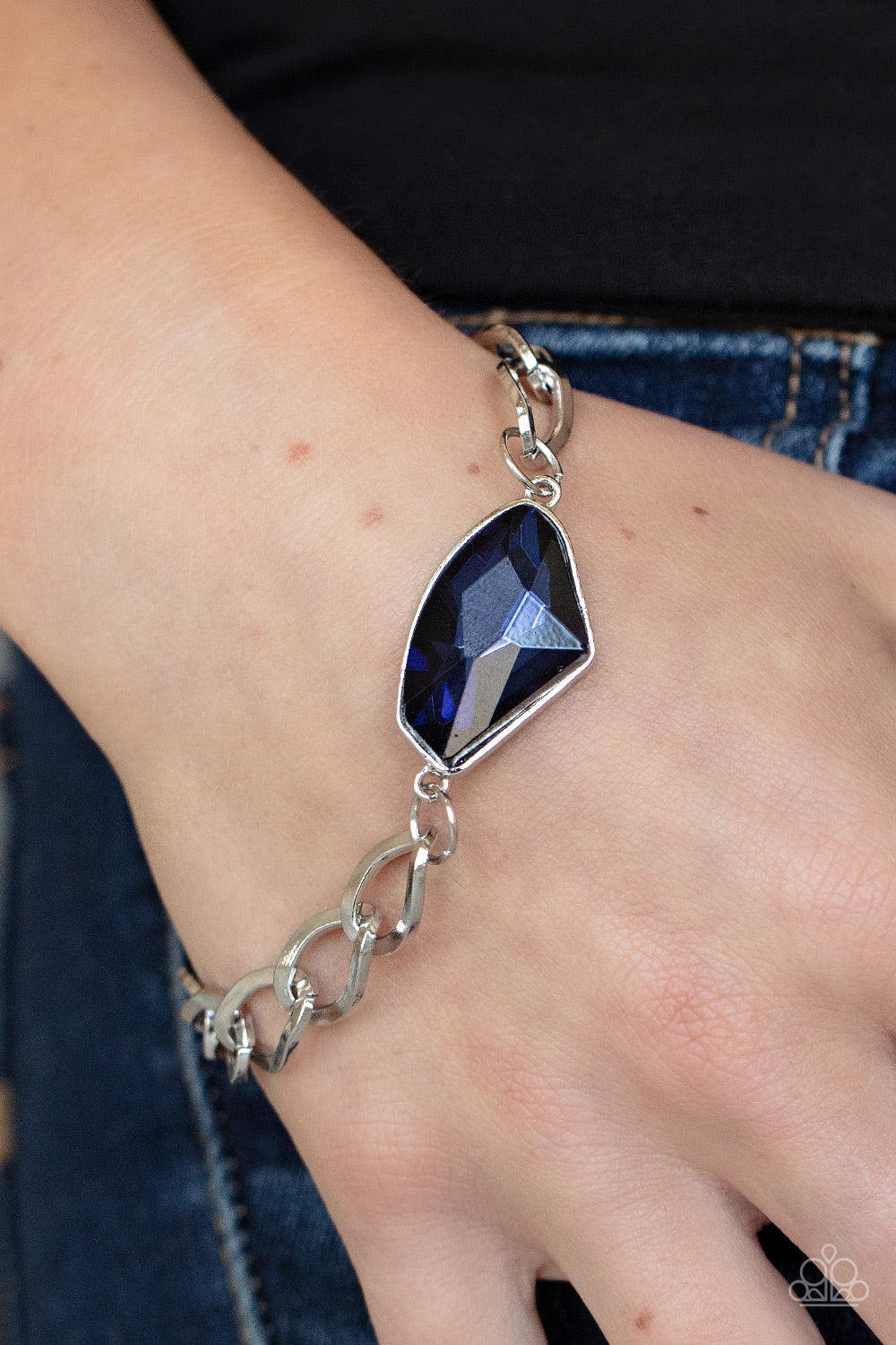 Galactic Grunge Blue Bracelet - Paparazzi Accessories  An oversized raw cut blue gem is pressed into a sleek silver frame that attaches to a bold silver chain around the wrist for a glitzy grunge fashion. Features an adjustable clasp closure.  Sold as one individual bracelet.