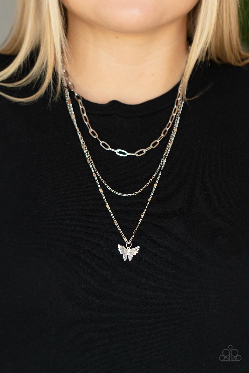 Bountiful Butterflies White Necklace - Paparazzi Accessories  Dotted with a dainty white rhinestone, a decoratively layered silver butterfly swings from the bottom of a display of mismatched silver chains for a whimsically fluttering fashion. Features an adjustable clasp closure.  Sold as one individual necklace. Includes one pair of matching earrings.