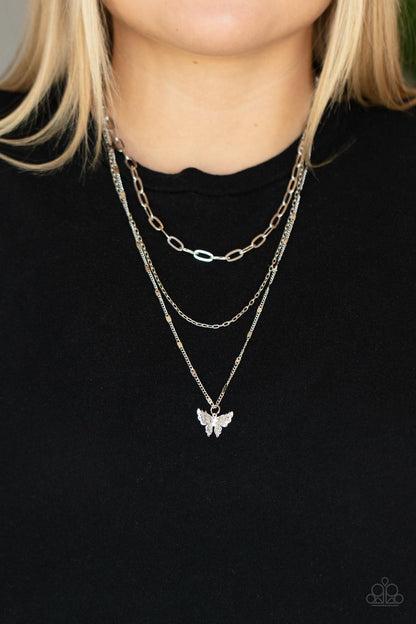Bountiful Butterflies White Necklace - Paparazzi Accessories  Dotted with a dainty white rhinestone, a decoratively layered silver butterfly swings from the bottom of a display of mismatched silver chains for a whimsically fluttering fashion. Features an adjustable clasp closure.  Sold as one individual necklace. Includes one pair of matching earrings.