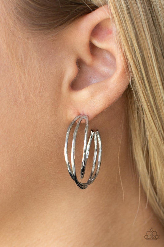 City Contour Silver Hoop Earring - Paparazzi Accessories  Glistening silver bars delicately overlap into a 3-dimensional frame, creating a dramatic hoop. Earring attaches to a standard post fitting. Hoop measures approximately 1" in diameter.  Sold as one pair of hoop earrings.