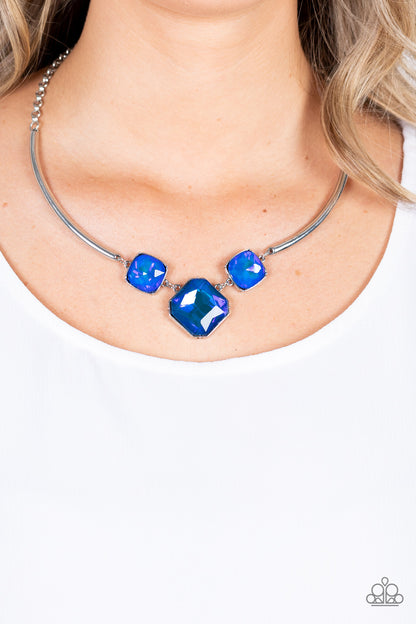 Divine IRIDESCENCE Blue Necklace - Paparazzi Accessories  Featuring a subtle UV shimmer, an oversized collection of radiant cut blue gems delicately link at the bottom of two curved silver rods. Attached to shiny silver chains, the glamorously glitzy display sparkles below the collar for a jaw-dropping finish. Features an adjustable clasp closure.  All Paparazzi Accessories are lead free and nickel free!  Sold as one individual necklace. Includes one pair of matching earrings.