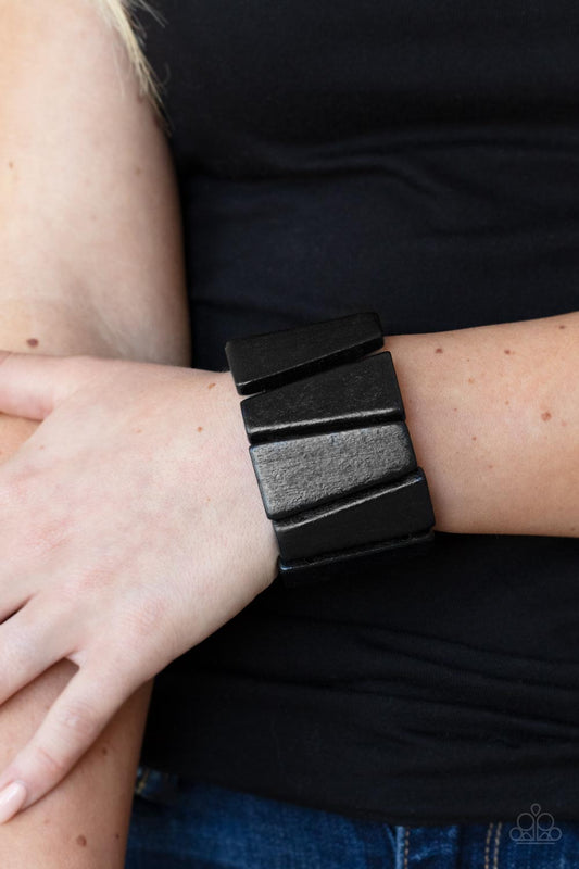 Barbados Backdrop Black Bracelet - Paparazzi Accessories  Painted in a shiny black finish, chunky triangular wooden frames are threaded along stretchy bands around the wrist for an earthy look.  Sold as one individual bracelet.