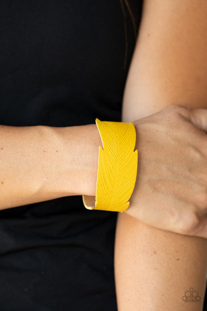 Whimsically Winging It Yellow Wrap Bracelet - Paparazzi Accessories   Featuring lifelike details, a golden yellow leather band is cutout into a whimsical feather that wraps around the wrist for a seasonal flair. Features an adjustable snap closure.  Sold as one individual bracelet.