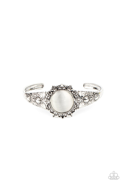 Extravagantly Enchanting - White Item #P9RE-WTXX-169XX A mystical white cat's eye stone is pressed into the floral center of a dainty silver cuff that is abloom with flowery details, creating an enchanting pop of color around the wrist.  Sold as one individual bracelet.
