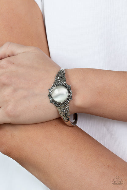 Extravagantly Enchanting - White Item #P9RE-WTXX-169XX A mystical white cat's eye stone is pressed into the floral center of a dainty silver cuff that is abloom with flowery details, creating an enchanting pop of color around the wrist.  Sold as one individual bracelet.