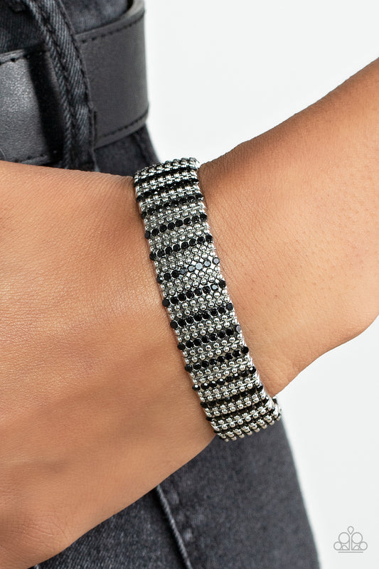 The GRIT Factor Black Bracelet - Paparazzi Accessories  Flanked by dainty silver studs, black rhinestone dotted silver frames are threaded along stretchy bands around the wrist for a gritty glamorous look.  All Paparazzi Accessories are lead free and nickel free!   Sold as one individual bracelet.