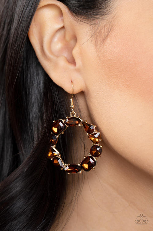 GLOWING in Circles Brown Earring - Paparazzi Accessories  Featuring glistening gold fittings, a regal assortment of round, triangular, teardrop, marquise, and emerald cut topaz rhinestones delicately coalesce into a jaw-dropping hoop. Earring attaches to a standard fishhook fitting.  Sold as one pair of earrings.