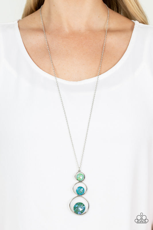 Celestial Courtier Green Necklace - Paparazzi Accessories  A sparkly ombré of opalescent green gems adorn the bottoms of three silver hoops that gradually increase in size as they stack into an asymmetrical pendant. The glowing pendant swings from the bottom of a lengthened silver chain, creating a stellar centerpiece. Features an adjustable clasp closure.  Sold as one individual necklace. Includes one pair of matching earrings.