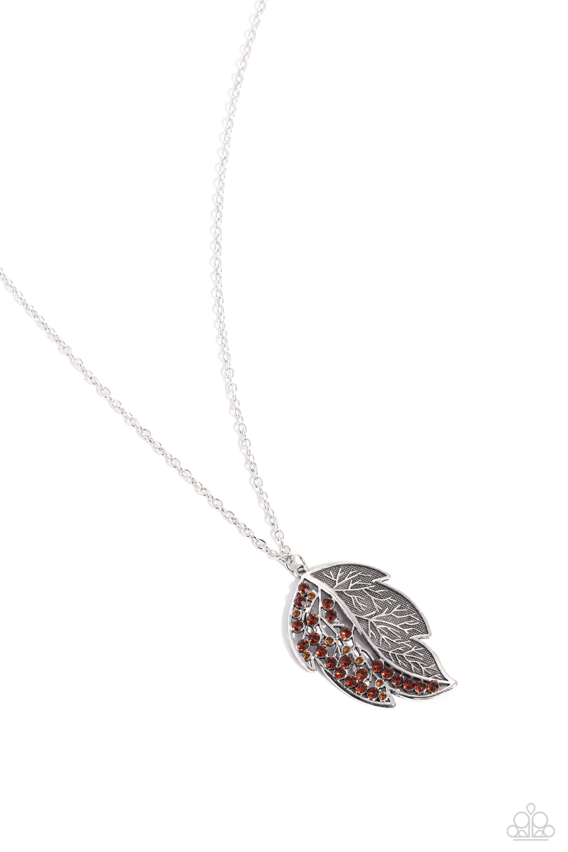 A Mid-AUTUMN Nights Dream Brown Leaf Necklace - Paparazzi Accessories  Half of a lifelike silver leaf frame is adorned in glittering topaz rhinestones as it hangs from the bottom of a lengthened silver chain, creating a simple seasonal sparkle. Features an adjustable clasp closure.  Sold as one individual necklace. Includes one pair of matching earrings.  Sku:  P2RE-BNXX-297XX
