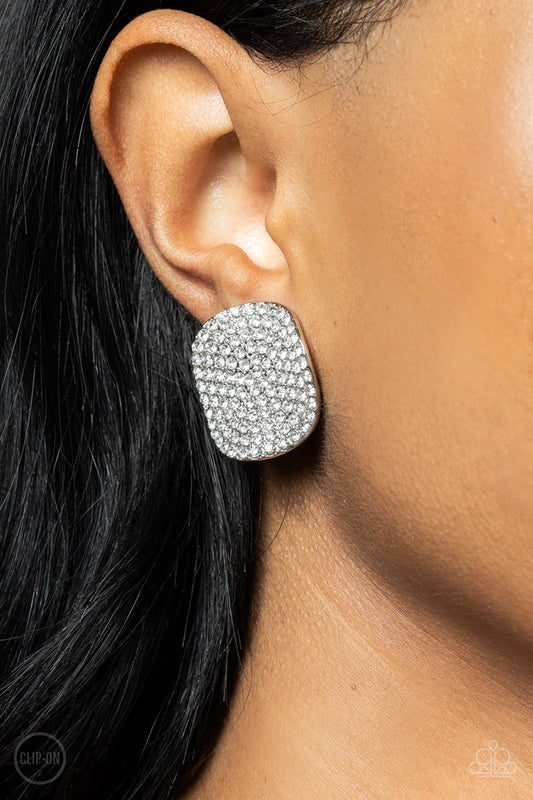 Lunch at the Louvre White Clip-On Earring - Paparazzi Accessories  The front of a warped silver disc is encrusted in row after row of blinding white rhinestones, resulting in a refined display. Earring attaches to a standard clip-on fitting.  Sold as one pair of clip-on earrings.