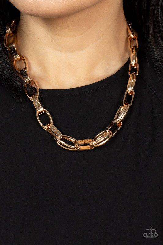 Motley In Motion Gold Choker Necklace - Paparazzi Accessories  Wide hammered gold links alternate with double sets of shiny gold links as they connect across the collar for an edgy industrial effect. Features an adjustable clasp closure.  Sold as one individual necklace. Includes one pair of matching earrings.