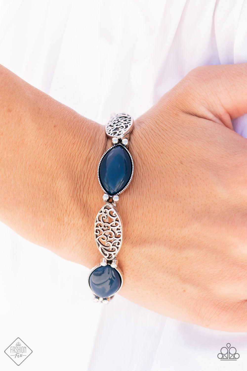 Garden Rendezvous Blue Bracelet - Paparazzi Accessories  Dewy Navy Blue opals set in daintily studded silver frames mingle with frames of swirling silver filigree as they alternate along stretchy bands for a whimsically wild fashion around the wrist.  All Paparazzi Accessories are lead free and nickel free!  Sold as one individual bracelet.