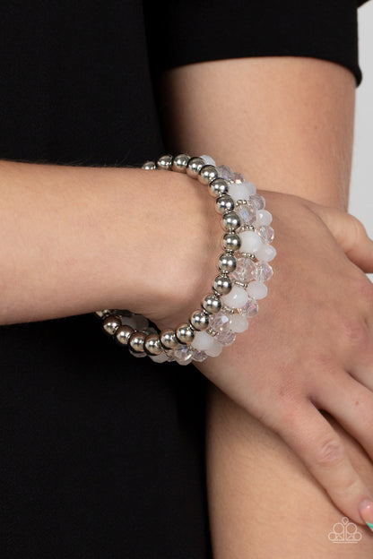 Gimme Gimme White Bracelet - Paparazzi Accessories  Sections of shiny silver beads and an alternating pattern of opaque and glittery white rhinestone gems gradually increase in size along a coiled wire, creating a jaw-dropping infinity wrap bracelet around the wrist.  Sold as one individual bracelet.
