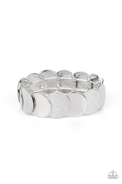 Demurely Disco Silver Bracelet - Paparazzi Accessories  A glimmering collection of shiny silver discs and glitter coated silver discs delicately overlap along stretchy bands around the wrist, creating a dazzling hint of shimmer.  Sold as one individual bracelet.