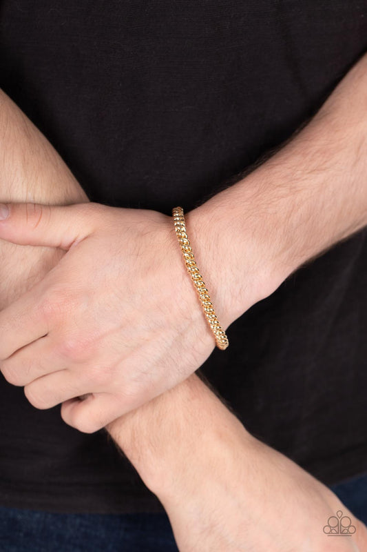 Setting The Pace Gold Unisex Stretch Bracelet - Paparazzi Accessories  Featuring round links, a gold chain is threaded along a stretchy band around the wrist for a classic urban look.  Sold as one individual bracelet.