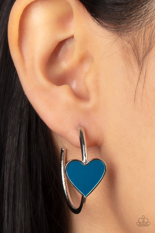 Kiss Up Blue Hoop Earring - Paparazzi Accessories  A charming Mykonos Blue heart adorns the front of a classic silver hoop resulting in a whimsical fashion. Earring attaches to a standard post fitting. Hoop measures approximately 1 1/4" in diameter.  Sold as one pair of hoop earrings.