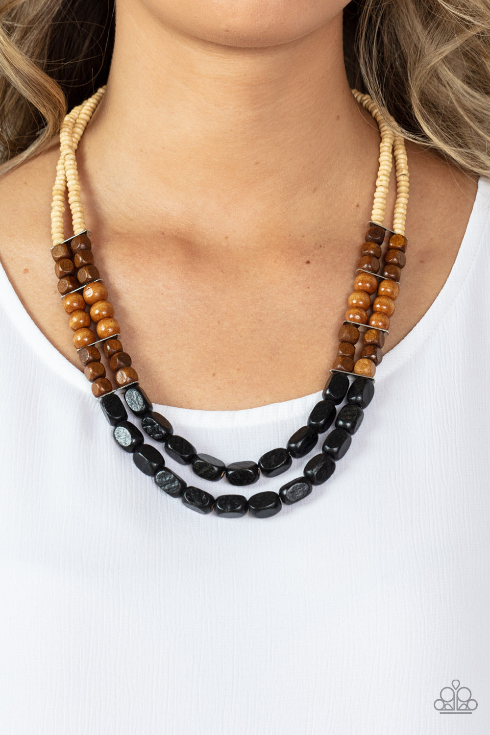 Bermuda Bellhop Black Wooden Necklace - Paparazzi Accessories  Varying in shape, size, and color, an earthy collection of white, brown, and black wooden beads are threaded along invisible wires across the chest, creating tropical inspired layers. Features an adjustable clasp closure.  Sold as one individual necklace. Includes one pair of matching earrings.
