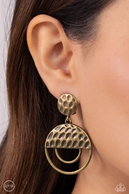 Southern Souvenir Brass Clip-On Earring - Paparazzi Accessories  A hammered brass disc gives way to a circular brass frame that is capped in a hammered half moon brass accent, resulting in a rustic lure. Earring attaches to a standard clip-on fitting.  Sold as one pair of clip-on earrings.  Sku:  P5CO-BRXX-029XX
