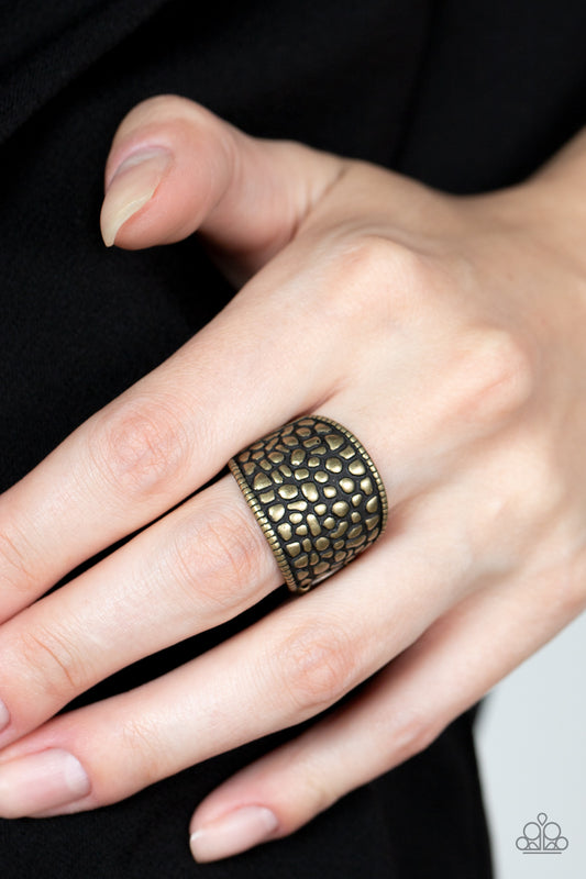Dotted Decorum - Brass Item #P4BA-BRXX-025XX Brimming from edge to edge with a studded texture reminiscent of cobblestone, a wide brass band is bordered in dainty studs resulting in a free-spirited fashion atop the finger. Features a stretchy band for a flexible fit.  Sold as one individual ring.