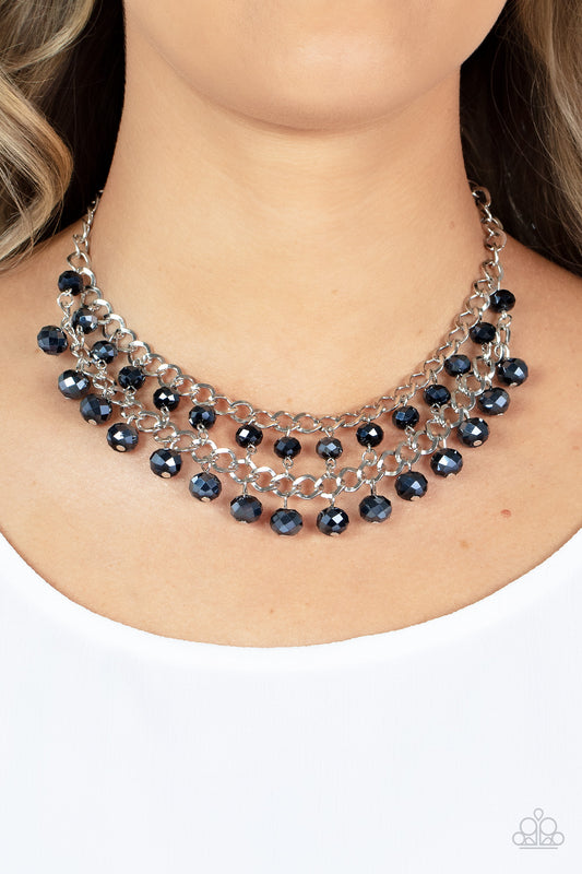 Urban Palace Blue Necklace - Paparazzi Accessories  Featuring metallic iridescence, two rows of flashy blue crystal-like beads cascade from the bottom of two interlocking silver chains, resulting in a radiant fringe below the collar. Features an adjustable clasp closure.  Sold as one individual necklace. Includes one pair of matching earrings.