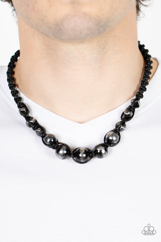 Loose Cannon Black Urban Necklace - Paparazzi Accessories  Brushed in shiny black accents, a gritty collection of faceted and round silver beads are knotted in place with braided black cording below the collar for an urban flair. Features a button loop closure.  Sold as one individual necklace.