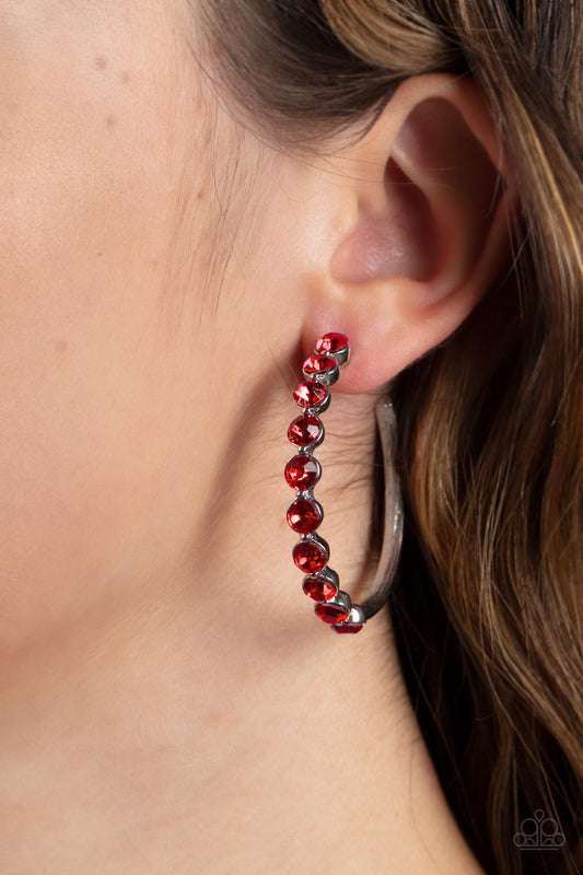 Photo Finish Red Rhinestone Hoop Earring - Paparazzi Accessories  The front of a bold silver hoop is encrusted in fiery red rhinestones, creating a glamorous pop of sparkle. Earring attaches to a standard post fitting. Hoop measures approximately 1 3/4" in diameter.  Sold as one pair of hoop earrings.